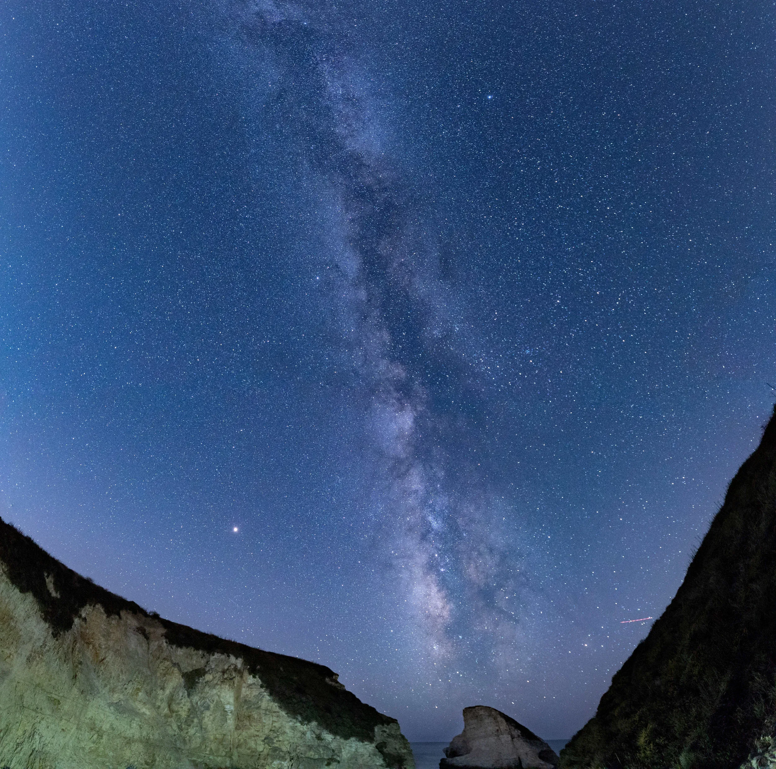 Panoramic night sky over cliffs